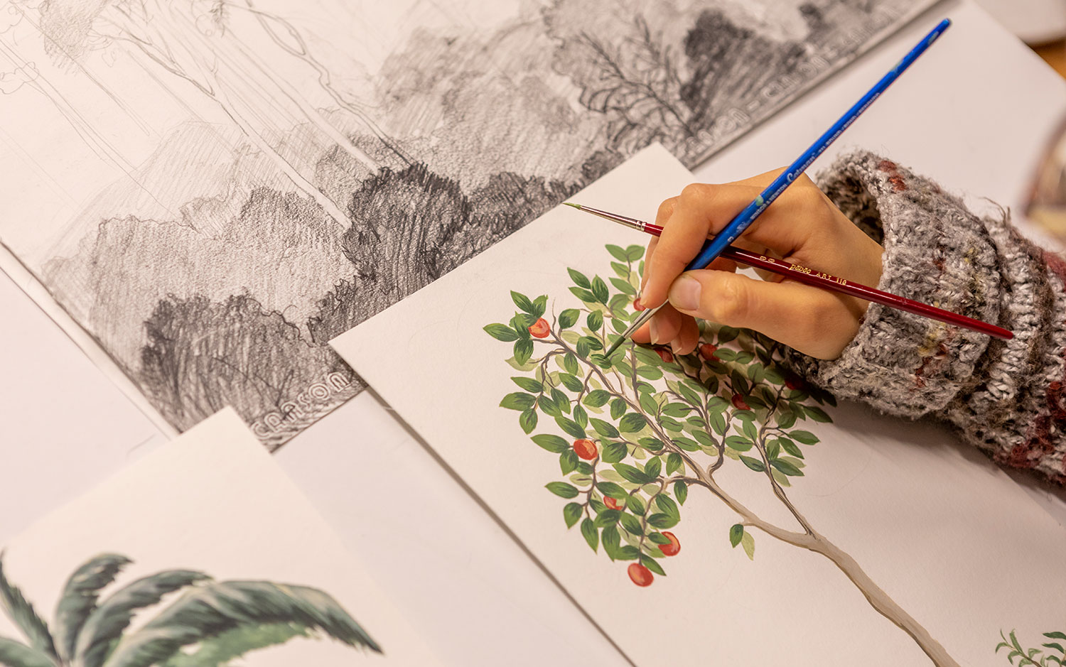 A designer sketching and painting a new wallpaper design